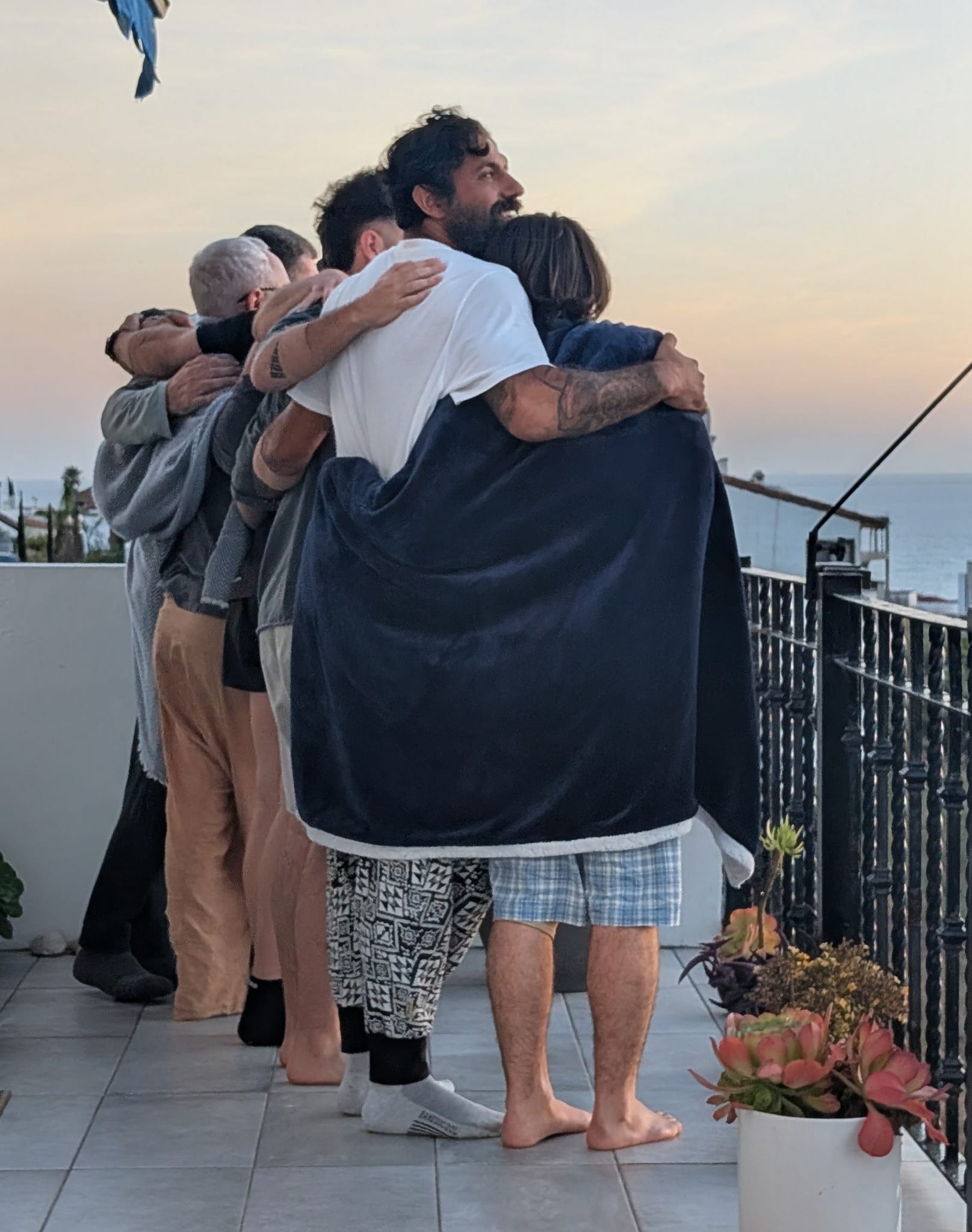 Veterans and clinicians embracing at sunset